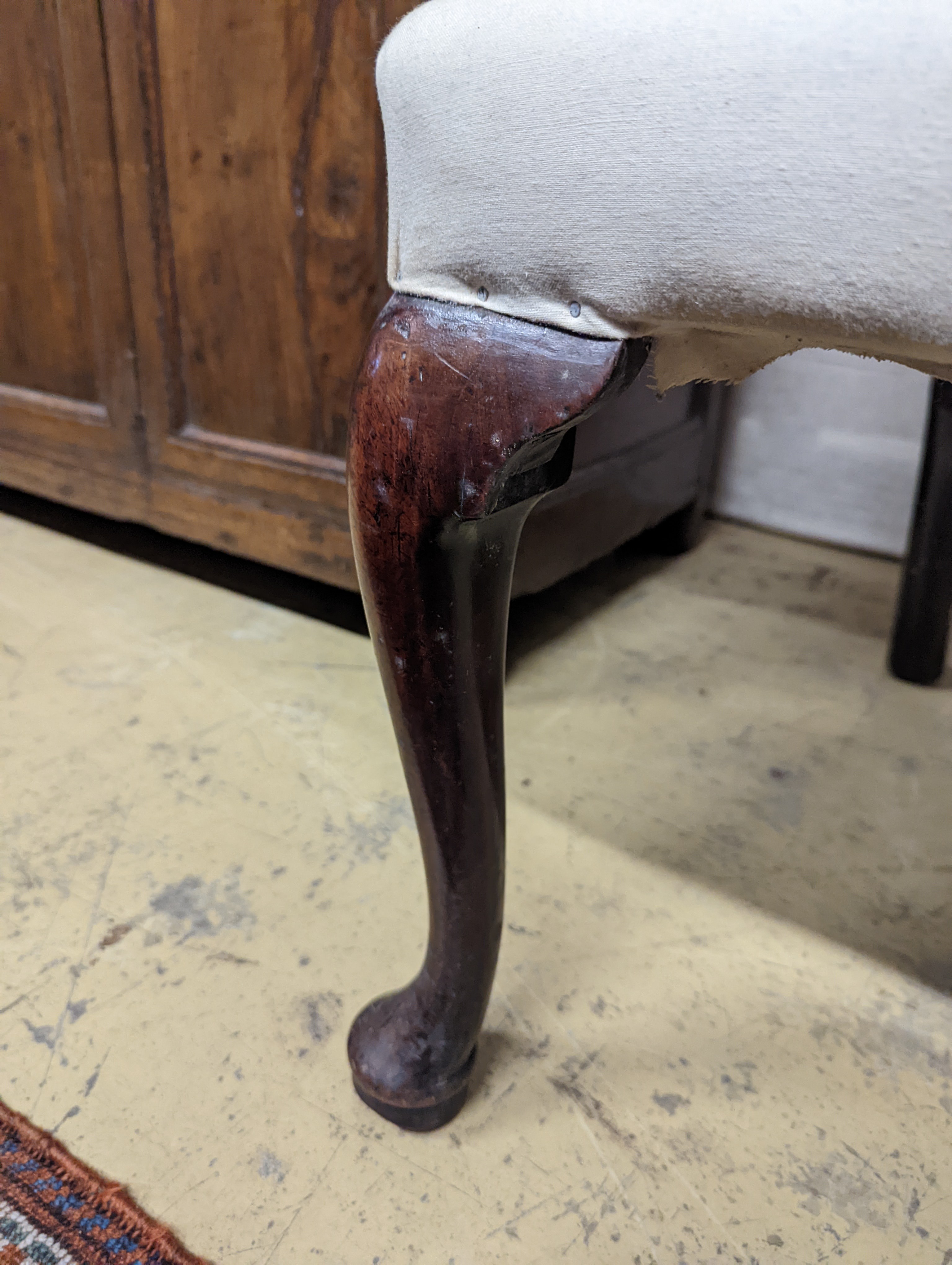 A George II mahogany wingback armchair, with slender cabriole legs and pad feet, width 80cm, depth 66cm, height 126cm